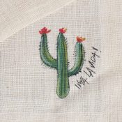 Cactus con fiori rossi alle estremità, disegnato su una tovaglia in canapa, a lato la scritta "viva la vida"