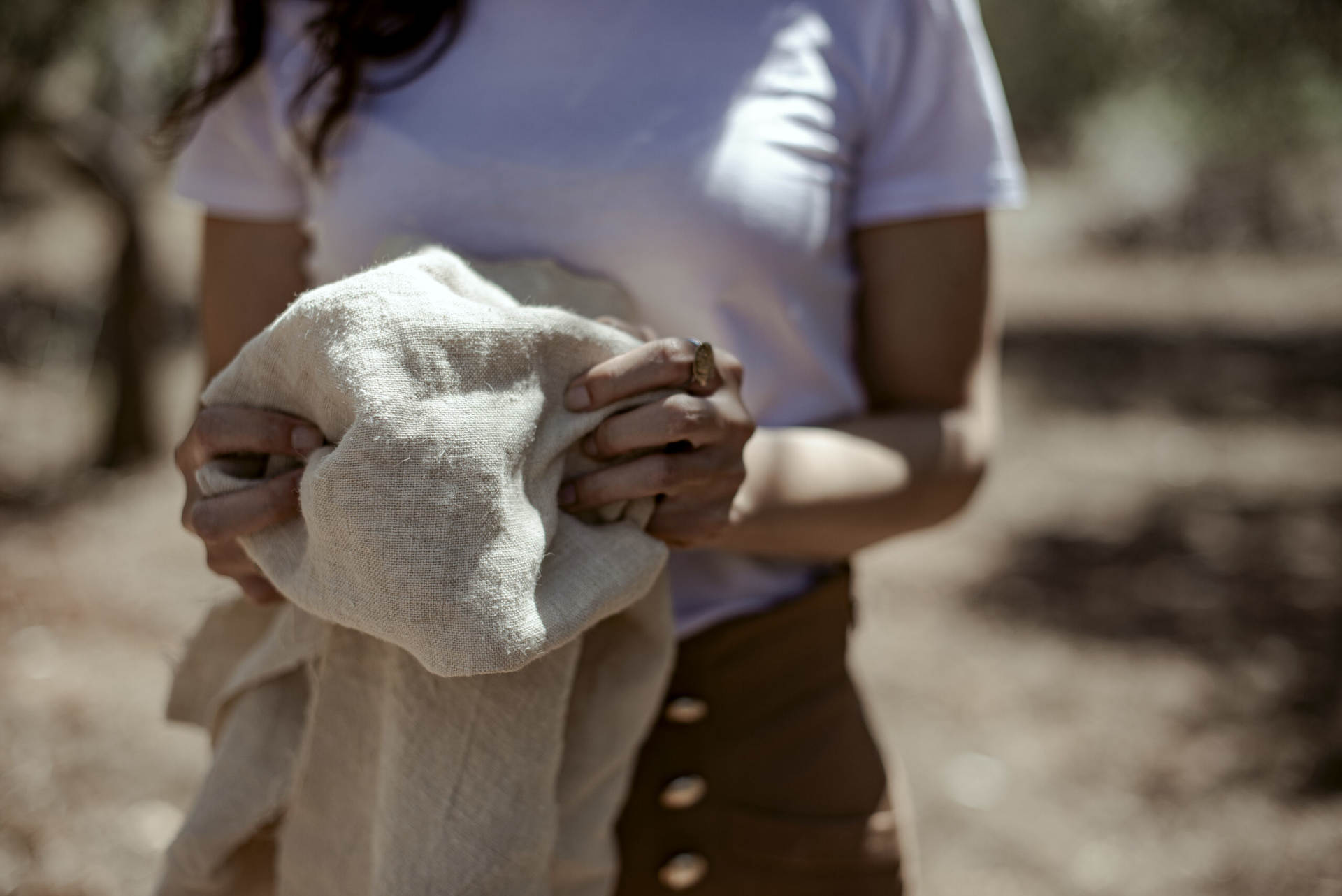 Ragazza che stringe tra le mani un tessuto in canapa - Progetto Tessicanapa