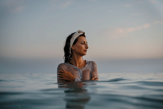 Ragazza immersa nell'acqua che indossa una fascia per capelli in canapa