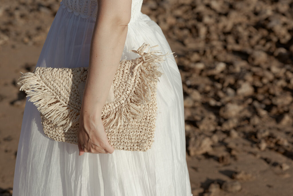 Borsa in rafia indossata con abito bianco